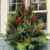 Spruce tip planter filled with evergreens and red berries.